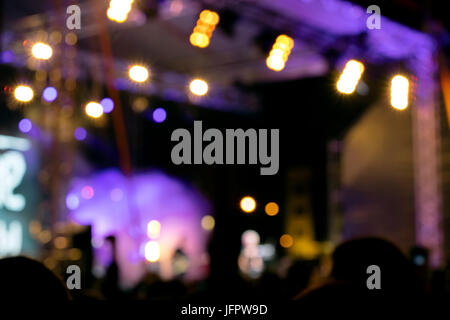 blurred lights of outdoor stage. silhouette of crowd at music concert. Stock Photo