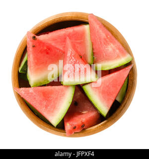Watermelon slices in wooden bowl. Triangular pieces of raw Citrullus lanatus. Edible fruit with green hard rind, black seeds and red, sweet flesh. Stock Photo