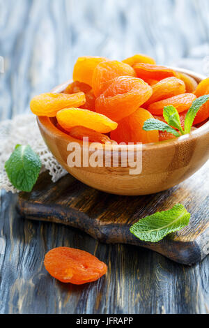 Wooden bowl of dried apricots. Stock Photo