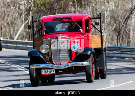 Vintage International Flat bed truck driving on country roads near the town of Birdwood, South Australia. Stock Photo
