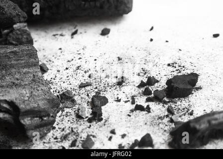 Black abstract textured composition on a white background, a selected focus close-up of a pile of cubes and powder of black mineral coal. Stock Photo
