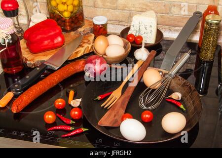 Steel frying pan on the stove. Kitchen utensils. Preparation of egg omelette. Diet food Stock Photo