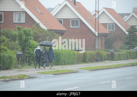 Sonderborg, Denmark - June 20, 2017: People on their way in strong rain. Stock Photo