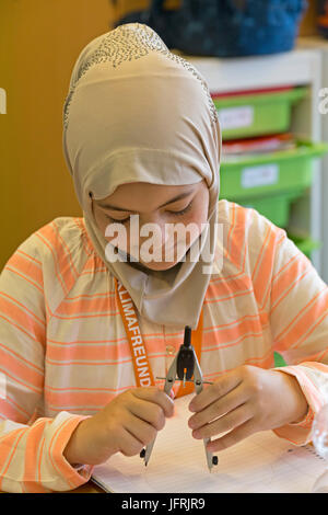 primary school girl working with her compasses Stock Photo - Alamy