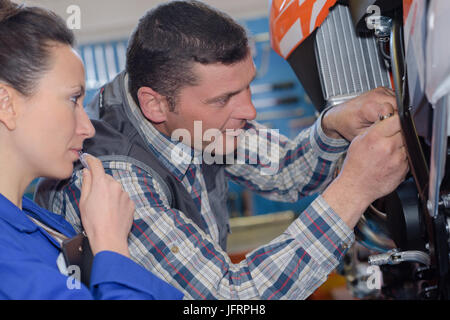 portrait of female mechanic and her coworker in the workshop Stock Photo