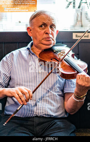 A fiddle player at a traditional music session at a pub in Dublin, Ireland Stock Photo