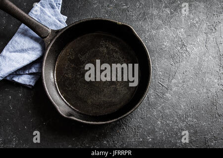 Cast iron pan on rustic black stone background close up -  empty black frying pan frying skillet with copy space Stock Photo
