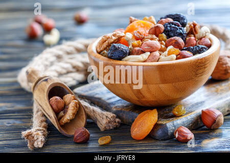 Mixture of nuts and dried fruit in a wooden bowl. Stock Photo