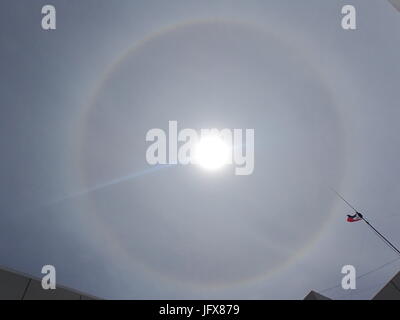 Marawi City, Philippines. 02nd July, 2017. Sun halo or rainbow around the sun appeared in the war-torn Marawi City. Halos were caused by both refraction, or splitting of light, and reflection, or glints of light from ice crystals in the atmosphere. Credit: Sherbien Dacalanio/Pacific Press/Alamy Live News Stock Photo