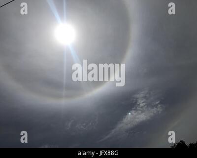 Marawi City, Philippines. 02nd July, 2017. Sun halo or rainbow around the sun appeared in the war-torn Marawi City. Halos were caused by both refraction, or splitting of light, and reflection, or glints of light from ice crystals in the atmosphere. Credit: Sherbien Dacalanio/Pacific Press/Alamy Live News Stock Photo