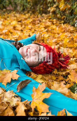 Beautiful woman lying on the dry autumn leaves Stock Photo - Alamy