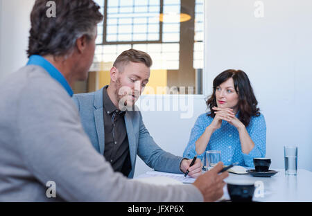 Three business colleagues having a meeting together in an office Stock Photo