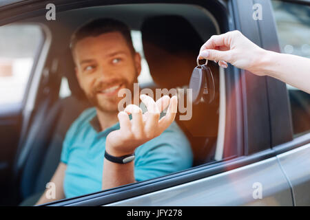 Beautiful bearded man receiving car keys Stock Photo