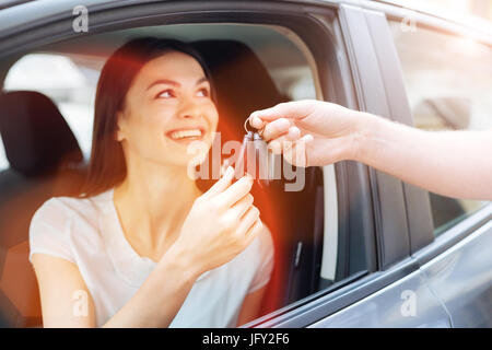 Happy charming woman receiving car keys Stock Photo