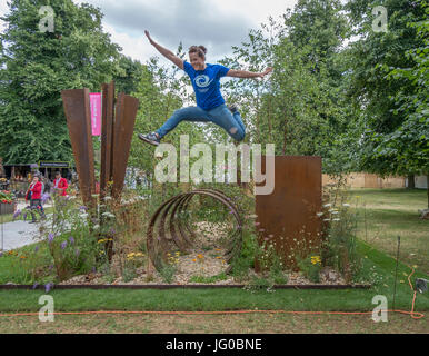 Hampton Court Palace, East Molesey, UK. 3rd July, 2017. Thuli Lamb, an urban free runner athlete from Parkour Generations, performs on the St Modwen Properties PLC: Brownfield - Metamorphosis garden. The world’s biggest annual flower show runs from 4-9 July, flanking both sides of the Long Water at Hampton Court Palace and includes Show Gardens, Rose Marquee, Floral Marquee and plant pavilions. Credit: Malcolm Park / Alamy Live News. Stock Photo