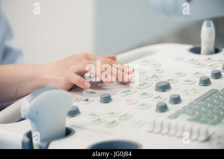 Hands on an ultrasound machine at modern clinic Stock Photo