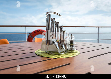 cutlery rack on a table in the outside area of the BELLA DONNA Restaurant aboard AIDAsol. AIDA Cruises is one of ten brands owned by Carnival Corp. Stock Photo