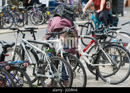 Man attaching a lock and chain to a bicycle to prevent theft in a city. Stock Photo