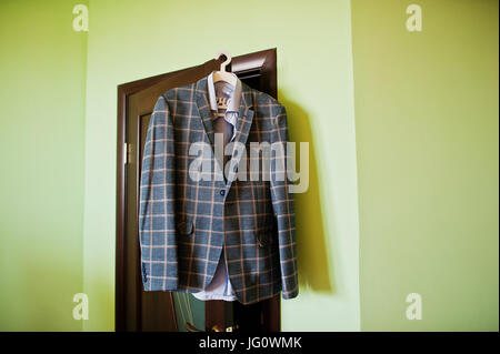 Handsome elegant bearded groom in checkered suit is standing on