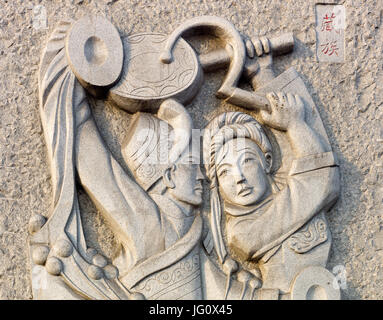 Bas relief stone carving in public park portraying Tibetan Chinese ethnic minority, Dawukou, Ningxia, China Stock Photo
