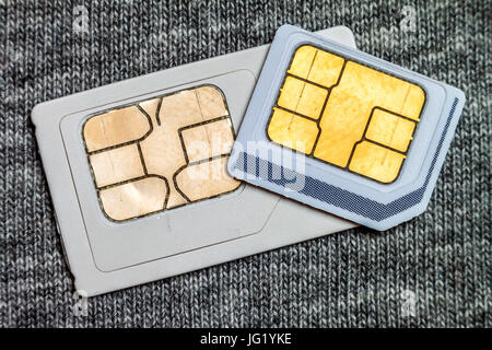 Set of mini and micro simcard. Isolated on grey cloth texture background Stock Photo