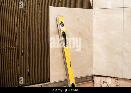 Ceramic tiles on a wall installation. Home improvement and renovation. Stock Photo