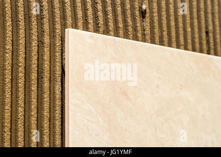 Ceramic tiles on a wall installation. Home improvement and renovation. Stock Photo