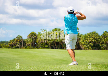 Golfer Hitting Ball on Beautiful Golf Course Stock Photo