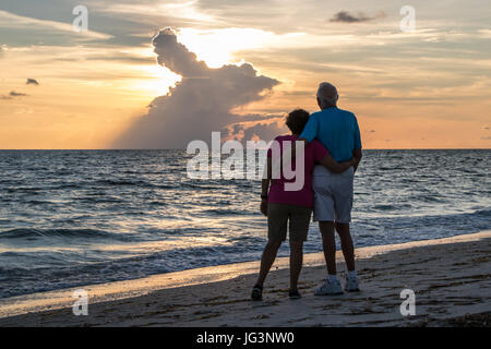 Retired Couple Embracing on Beach Stock Photo