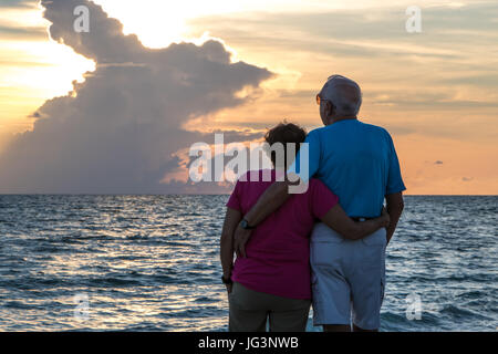 Retired Couple Embracing on Beach Stock Photo