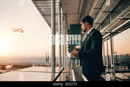 Airport lounge balcony and looking at airplane take off. Business man waiting for his flight. Stock Photo