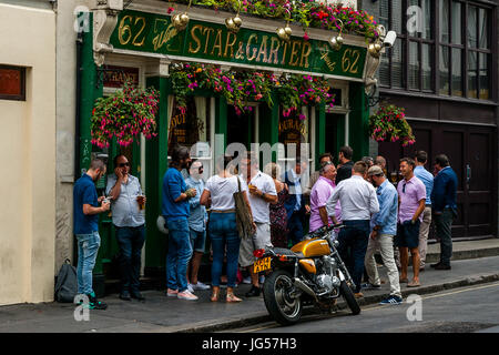 A Large Group Of People Drinking Outside The Star and Garter Pub, Poland Street, London, UK Stock Photo