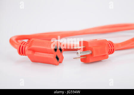 Bright orange extension cord on a white surface. Orange extension cable isolated on white background. Stock Photo