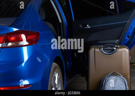 Open car rear door with luggage bags. Car travel background Stock Photo