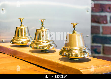 Three shiny golden vintage bells in a row Stock Photo