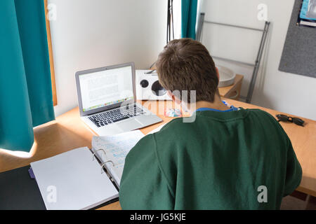 University student UK studying at a desk in his room, Queens College, Cambridge university UK Stock Photo