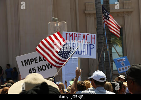 'Impeach Trump,' 'Impeach 45 Now' posters and American flags waving above the heads of protestors at the Impeachment March in San Diego, CA on July 2. Stock Photo