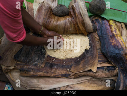 A Dorze woman prepares unleavened bread made from the false banana tree, Gamo Gofa Zone, Gamole, Ethiopia Stock Photo