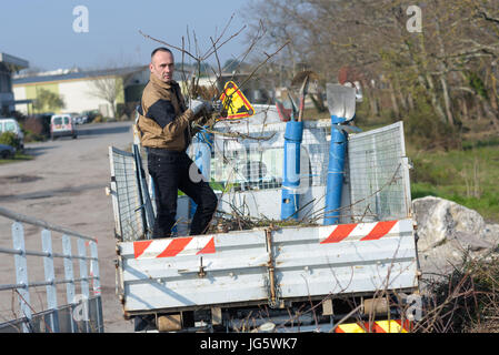 man emptying litter from truck trailer at the community landfill Stock Photo