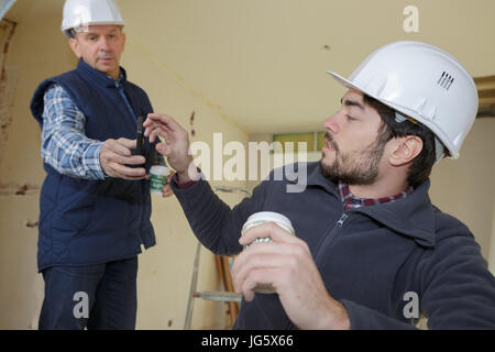 builders talking while having a coffee break Stock Photo