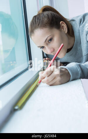 female worker measuring window glass Stock Photo
