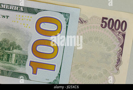 Many kind of banknotes - close up. US 100 dollar bill and Japan 5,000 yen bill. Stock Photo