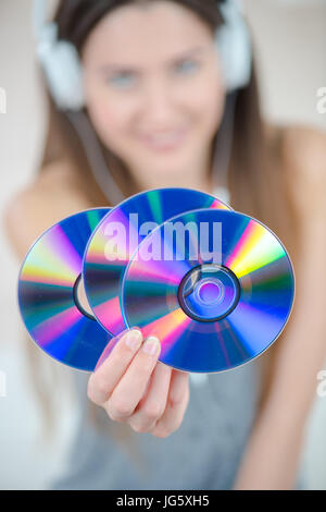 young woman listening music and showing cds Stock Photo