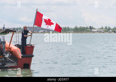 Toronto, Canada - 26 June 2017: Fireman raising a canadian flag at Toronto Harbourfront Stock Photo