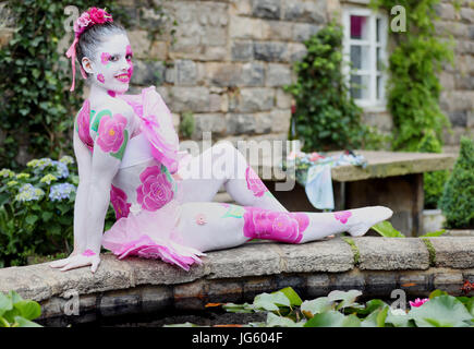 A model painted as a camellia flower in the Pazo's Secret Garden during the press day for the RHS Hampton Court Palace Flower Show 2017 at Hampton Court, London. Stock Photo