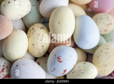 Overhead close up (macro) of a pile of Egg shaped Easter sweets (candies) in pastel shades. Stock Photo