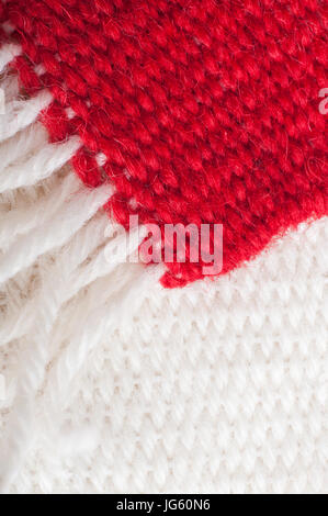 Two weaving samples from a beginners loom.  A plain red piece with light cream fringing rests diagonally above a light cream sample. Stock Photo