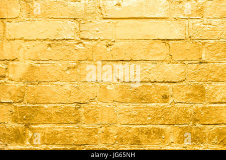 brick wall  painted in gold - golden graffiti background Stock Photo