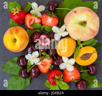 Summer fresh sliced fruits on slate. Love for a healthy vegan food concept. Stock Photo