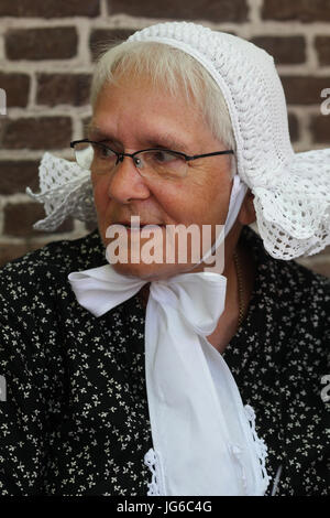 Senior women wearing traditional Dutch caps or bonnets made of white ...